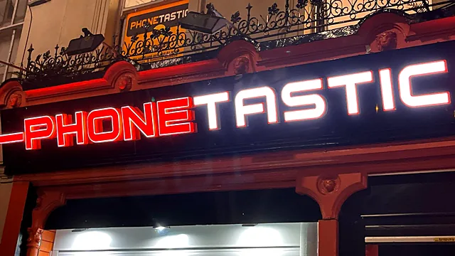 Phonetastic fascia in Cork at night: red and white illuminated 3D letters on a black fascia.