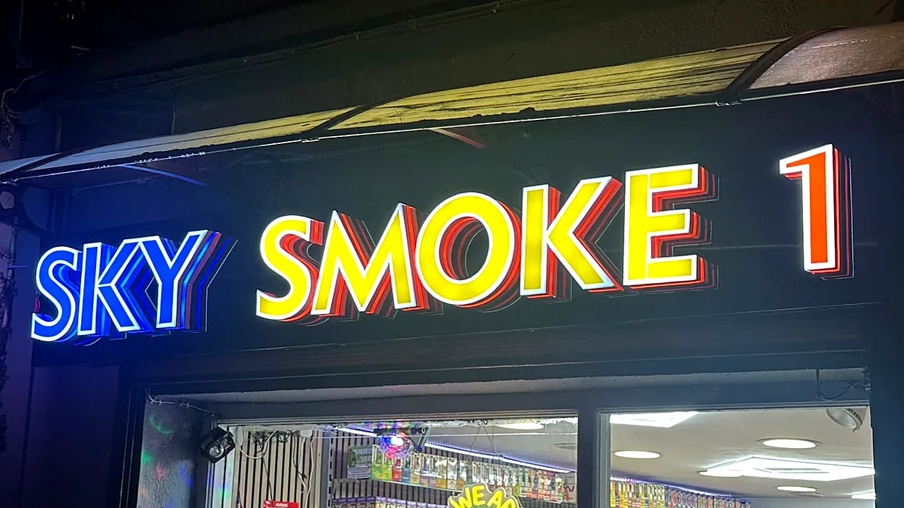 Sky Smoke 1 in Cork at night: blue, yellow and orange illuminated 3D letters.