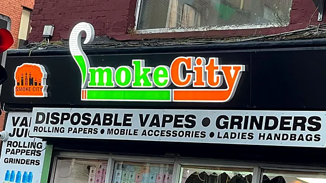 Smoke City on South Main Street, Cork: green and orange illuminated letters with a lit logo box above a printed fascia.